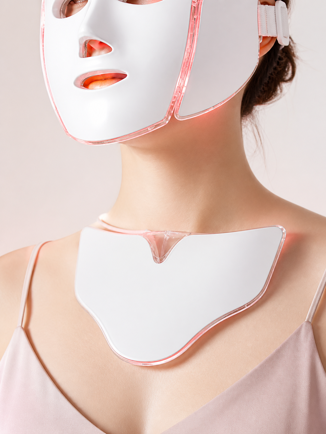 White V-shaped PhotonMask chest attachment glowing on a studio bust